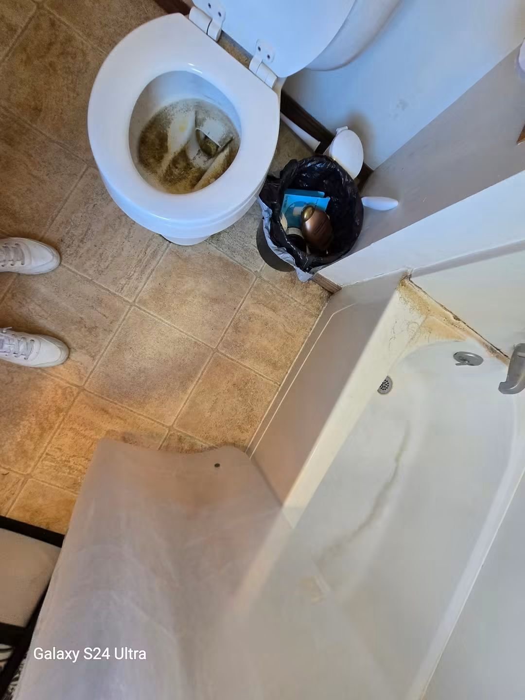 Bathroom before cleaning — stained toilet and dirty tile floor